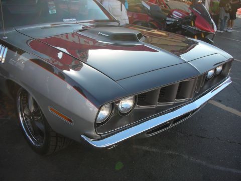 1998 Ford Crown Victoria - Front three-quarter view of a gray Plymouth Barracuda muscle car with quad headlights, chrome bumper, and a hood scoop.