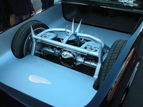 1998 Ford Crown Victoria - light blue custom truck bed showcasing a polished chrome independent front suspension and spare tire as a display piece.