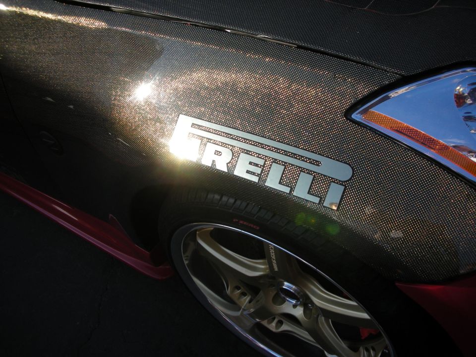 Carbon-fiber fender with chrome Pirelli emblem above a five-spoke wheel