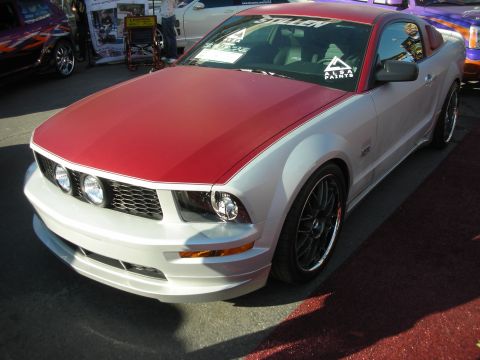 1998 Ford Crown Victoria - silver Ford Mustang coupe with a contrasting red hood and black wheels sits parked on pavement.