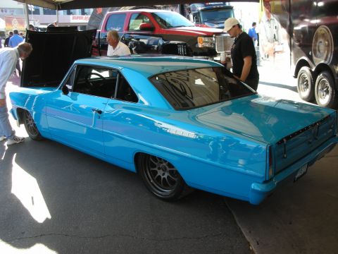 1998 Ford Crown Victoria - Bright turquoise two-door classic muscle car with dark wheels and open trunk parked at an outdoor car show.