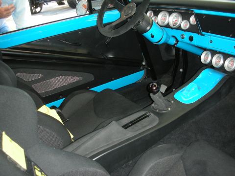 1998 Ford Crown Victoria - Minimalist race interior featuring a turquoise painted dash with round gauges, a floor shifter, and black carpeting.