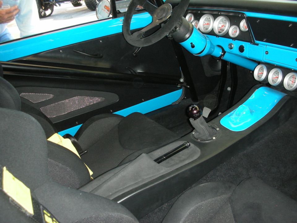 Stripped race interior with turquoise dash, gauges, floor shifter and black carpet