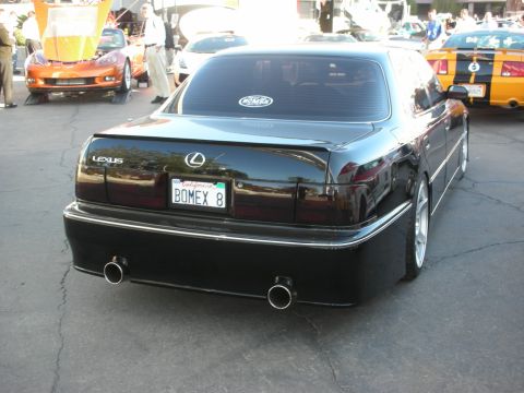 1998 Ford Crown Victoria - black lowered Lexus sedan shown from behind with dual round exhaust tips and a California plate reading BOMEX 8.