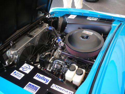 1998 Ford Crown Victoria - Detailed engine bay of a blue car featuring a large round chrome air cleaner, dual cooling fans and Holley and Auto Meter decals.