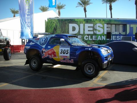 1998 Ford Crown Victoria - blue Volkswagen Red Bull off-road rally race truck numbered 305 displayed in front of a Diesel banner outdoors.