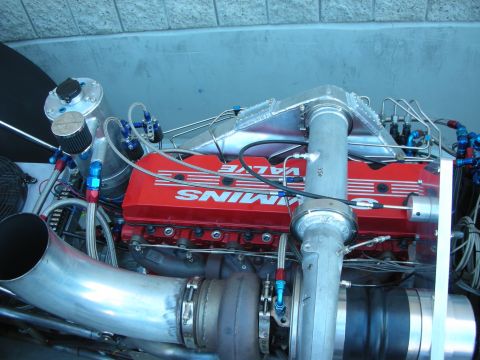 1998 Ford Crown Victoria - diesel engine with red Cummins valve covers, chrome intake piping and turbo sits in a dragster chassis.