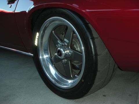 1998 Ford Crown Victoria - polished five-spoke rear wheel with a wide Nitto tire fills the wheel well of a dark-red show car.