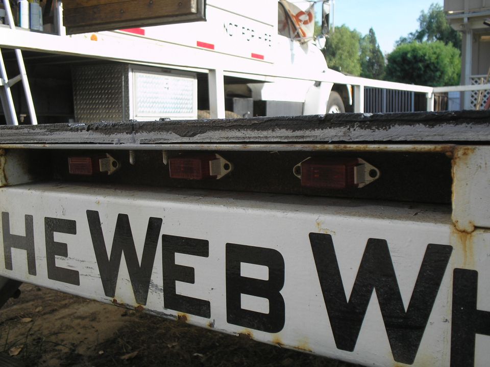 Trailer with red lights and black text "HE WEB WH"