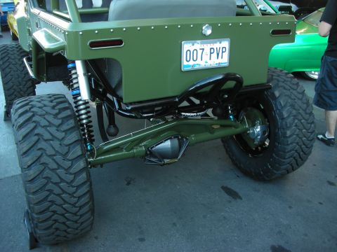 1998 Ford Crown Victoria - Rear three-quarter view of an olive-green tube-frame off-road buggy with blue coilover shocks and a Nevada license plate reading 007 PVP.
