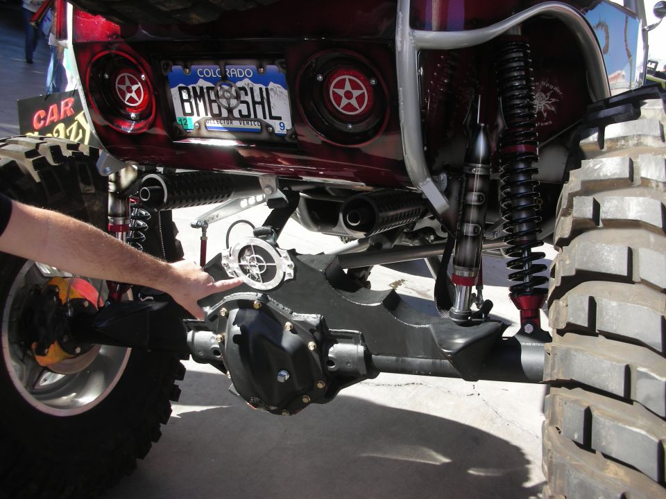 Rear axle and shocks under lifted truck with Colorado plate and speaker grilles