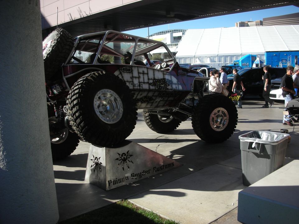 Tube-chassis rock crawler on display block on huge tires at outdoor show