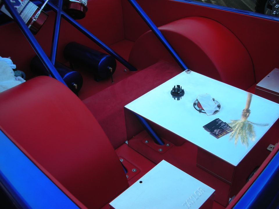 Red and blue custom interior with bare floor, air tank and brochure on panel