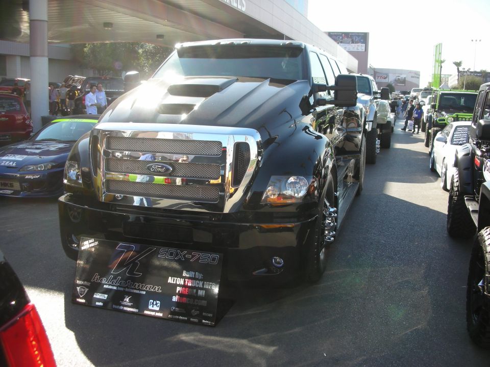 Front of black custom Ford medium-duty truck with chrome grille at car show