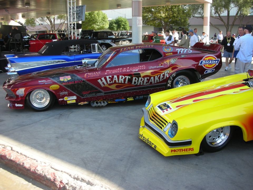 Maroon Mustang funny car and yellow flamed coupe at outdoor car show