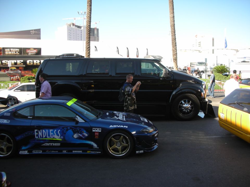 Blue drift car beside lowered black SUV in show parking lot