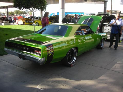 1998 Ford Crown Victoria - bright green custom Dodge muscle car with a biohazard graphic, black wheels and open hood displayed at a car show.