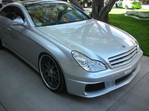1998 Ford Crown Victoria - Front three-quarter of the lowered silver Mercedes-Benz CLS showing a custom body kit, projector lights and dark multi-spoke wheels.
