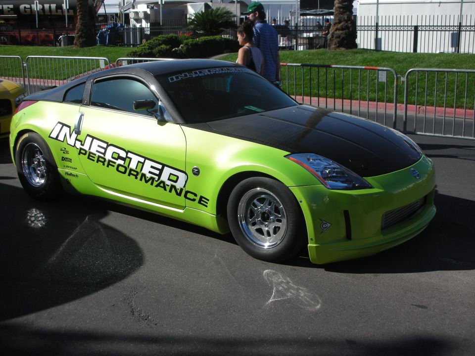 Green and black Nissan 350Z race car with Injected Performance livery in a parking lot