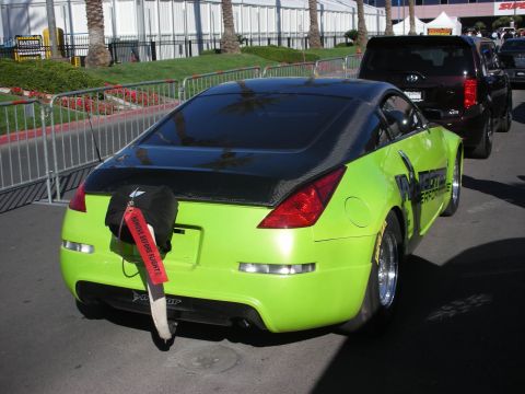 1998 Ford Crown Victoria - Rear three-quarter view of a green Nissan 350Z drag car with a black roof, mounted drag parachute and 'Injected Performance' graphics.