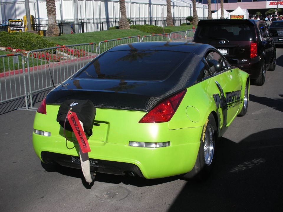 Rear view of green Nissan 350Z race car with parachute and Injected Performance graphics
