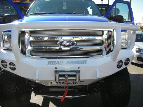 1998 Ford Crown Victoria - Front view of a white lifted Ford Super Duty truck fitted with a Road Armor bumper, PIAA driving lights and a winch.