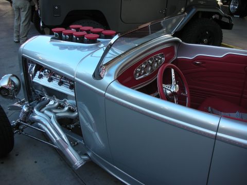 1998 Ford Crown Victoria - Close detail of a silver hot rod roadster's red leather interior, polished chrome engine and inset Audi-style headlight rings.