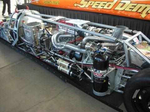 1998 Ford Crown Victoria - exposed tube-chassis and turbo-plumbed engine of a 'Speed Demon' drag car, with a nitrous bottle mounted at the rear.