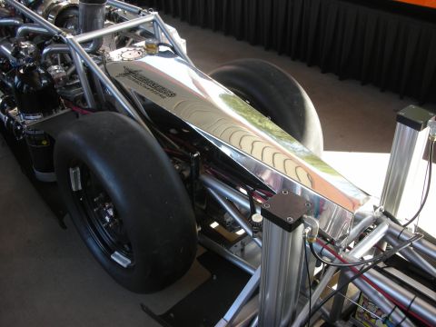 1998 Ford Crown Victoria - polished tube chassis, chrome fuel tank and slick rear tires of a dragster displayed against a black backdrop.