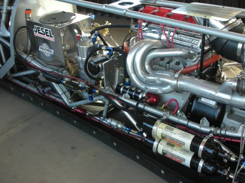 1998 Ford Crown Victoria - detailed drag car engine bay showing Jesel-branded components, polished headers, braided lines and twin nitrous bottles.