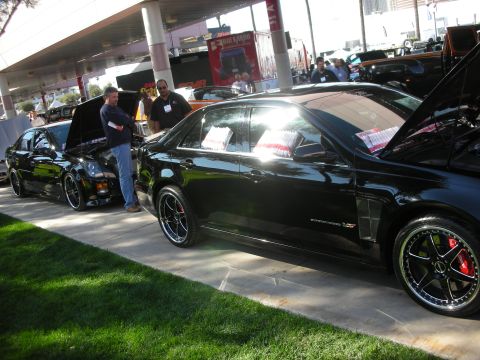 1998 Ford Crown Victoria - black Cadillac STS-V sedan with a supercharged V8, black multi-spoke wheels and red brake calipers displayed at an outdoor show.