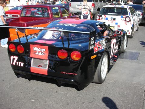 1998 Ford Crown Victoria - Rear view of a black and red Chevrolet Corvette race car numbered 17 TTR with a wing and a Whoop Ass graphic.