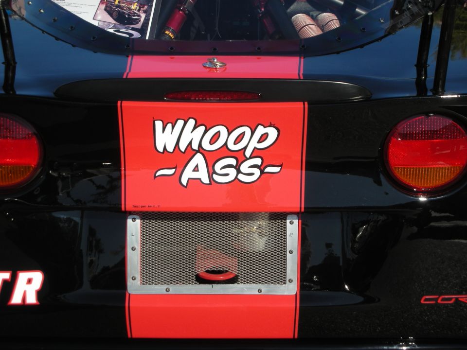 Close-up of Corvette rear deck red panel with cartoon Whoop Ass lettering and tail lights