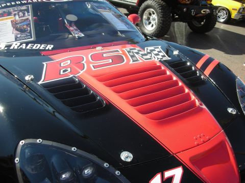 1998 Ford Crown Victoria - Detail of a black and red Corvette hood featuring louvered center vents and a BSM checkered-flag racing graphic.