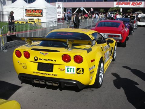 1998 Ford Crown Victoria - Rear view of a yellow Chevrolet Corvette GT1 race car with Motorola livery and rear diffuser in a lineup at the SEMA show.