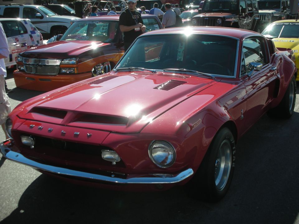 Red Shelby Mustang fastback front three-quarter with hood scoops and chrome bumper