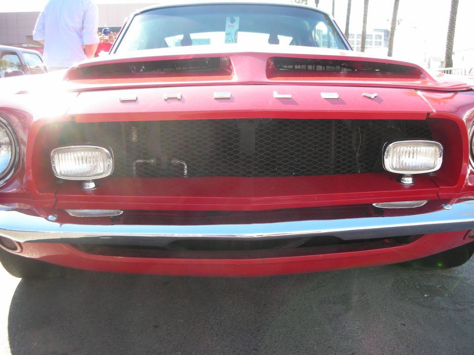Front grille and Shelby lettering of red Mustang fastback with twin driving lights