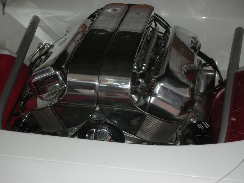 1998 Ford Crown Victoria - heavily chromed and polished V-engine with twin valve covers sits in a clean white-walled engine compartment.