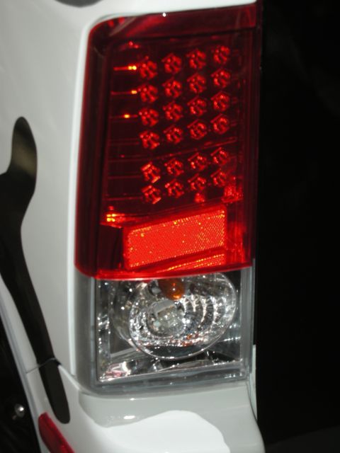 1998 Ford Crown Victoria - Detailed close-up of a red and clear LED taillight assembly mounted on a white vehicle body.