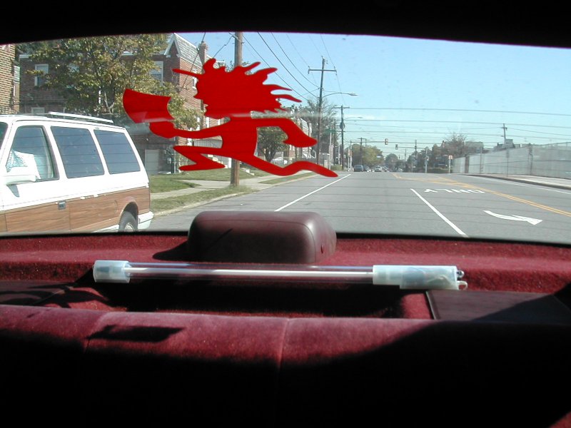 Rear window from inside showing red Hatchetman decal, dark red parcel shelf, tube light, and street beyond