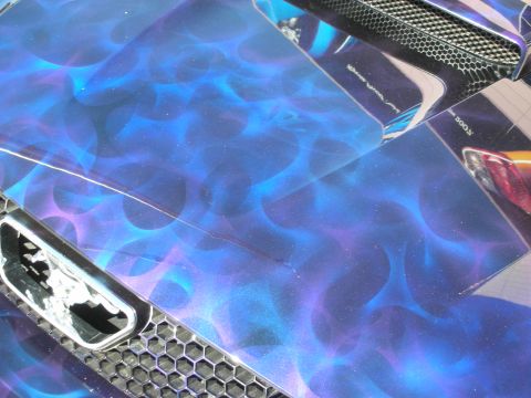1998 Ford Crown Victoria - Detail of a vehicle's hood and grille finished in vivid blue-and-purple airbrushed flame paint with chrome mesh accents.