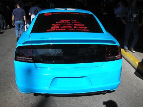 1998 Ford Crown Victoria - Rear view of a light blue Dodge Charger sedan with a spoiler and red sponsor decals across the rear window at an indoor show.