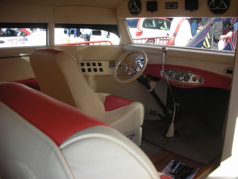 1998 Ford Crown Victoria - Interior of a custom hot rod with cream-and-red leather bucket seats, a chrome steering wheel and a tall floor shifter.