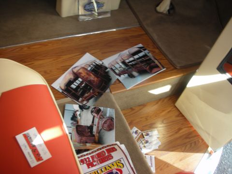 1998 Ford Crown Victoria - cluttered display of printed photographs and a magazine spread showing a hot rod, laid out on a wood-grain surface.