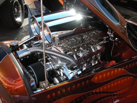 1998 Ford Crown Victoria - Highly chromed supercharged V8 engine with polished tubes mounted in an orange flame-painted hot rod engine compartment.
