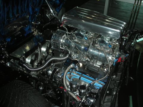 1998 Ford Crown Victoria - Polished supercharged V8 engine with blue-painted components mounted in a blue flame-painted engine bay.