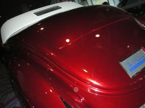 1998 Ford Crown Victoria - Glossy deep red rear deck of a custom car with white roof trim and a license plate frame reading The OQuinn Car Collection.