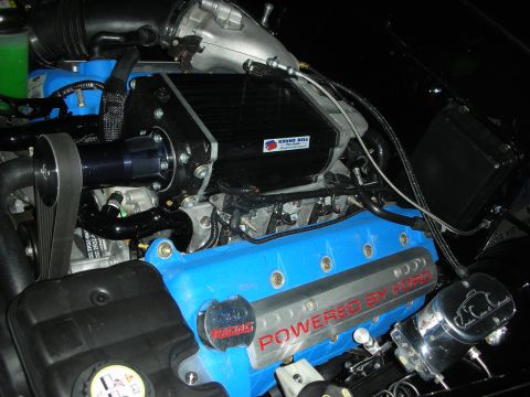1998 Ford Crown Victoria - Supercharged Ford V8 with a blue Powered by Ford valve cover and a Kenne Bell-labeled blower in a dark engine bay.