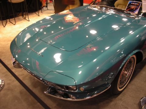 1998 Ford Crown Victoria - Front three-quarter view of a teal custom convertible with airbrushed graphics, chrome bumper, and chrome wire wheels at an expo.