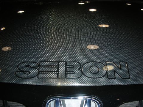 1998 Ford Crown Victoria - carbon-fiber hood marked with the Seibon logo sitting above a chrome Honda emblem on a black vehicle.